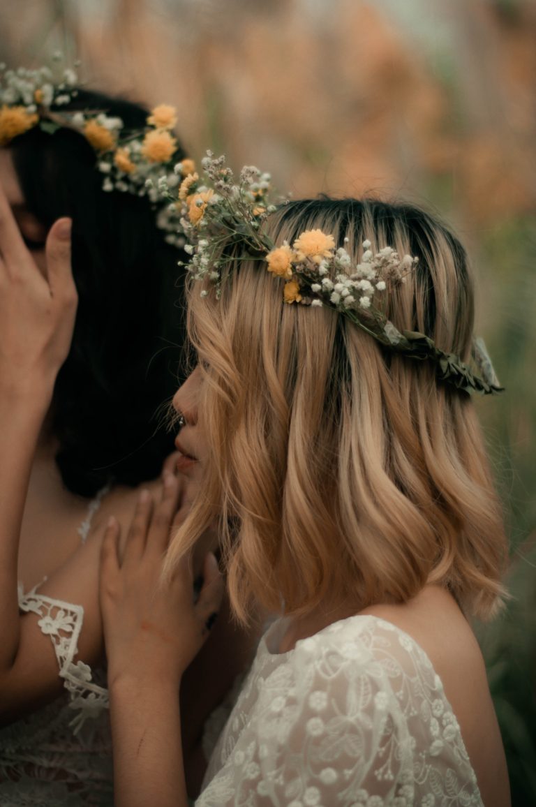 Bride posing with her hairstylist on her wedding day.